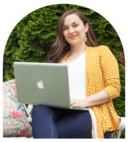 An image of Katie sitting in front of a tree with her laptop, smiling.